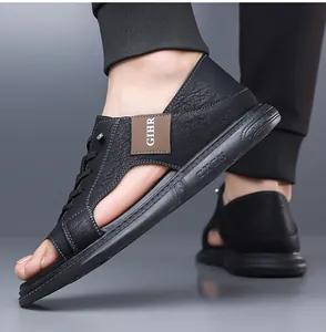 Detail van het getextureerde leer en het opengewerkte ontwerp van zwarte herensandalen.