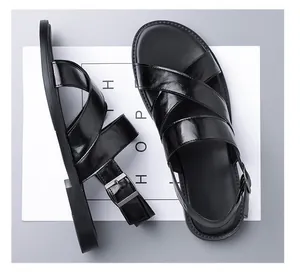 Overhead view of black men's leather sandals with cross-straps and buckle detail