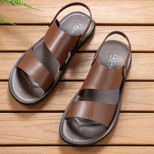 A top-down view of stylish men's brown breathable beach sandals on a rustic wooden deck