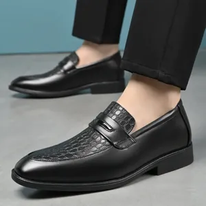 Close-up detail of black men's loafers with crocodile embossed pattern and slip-on design.