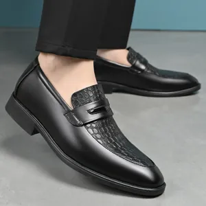 Close-up of men's black leather loafers with textured crocodile pattern vamp