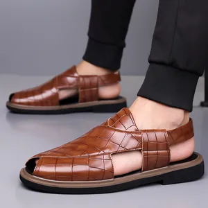 Vista lateral detallada de sandalias de hombre con textura de cocodrilo marrón y suela suave.