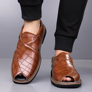 Primer plano de sandalias de cuero marrón para hombre con textura de piel de cocodrilo.