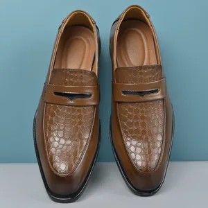 Close-up detail of brown British style leather loafers with crocodile pattern texture