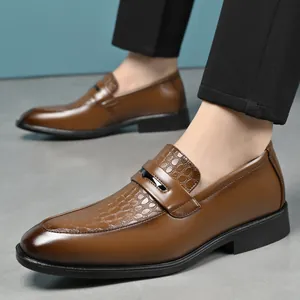 Detail view of brown leather loafers with crocodile texture and pointed toe design.