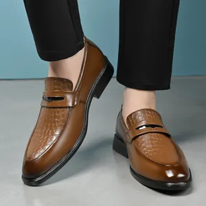 Close-up detail of brown crocodile-textured leather loafers for men in business casual style