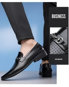 Detail view of men's black business loafers with perforated design and metal buckle decoration