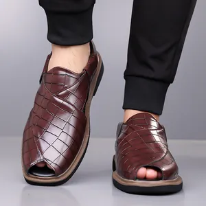 Detalle de sandalias romanas de hombre marrones con patrón de cocodrilo y suela blanda