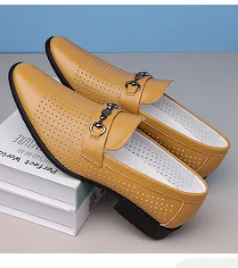 Detail of tan business casual loafers with laser-cut patterns and metal buckle.