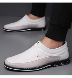 Dettaglio laterale di mocassini casual da uomo bianchi e grigi indossati da un modello