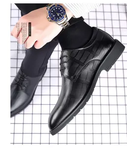 Macro view of black embossed leather elevator dress shoes for men's formal business wear.