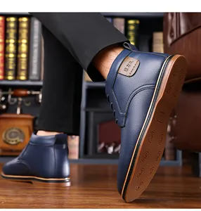 Close-up of men's navy blue high-top leather boots with patterned sole.