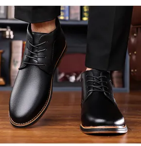 Classic black pebbled leather men's business casual high-top boots on a warm wooden floor