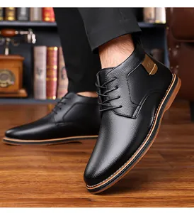 Detail of black leather business casual short boots for men on wooden floor