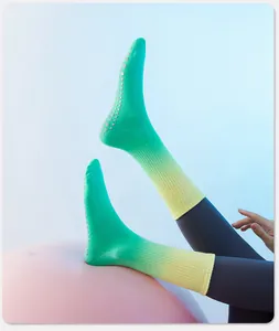 Detail van groene yoga-sokken met kleurverloop en antislip siliconen stippen op de zool