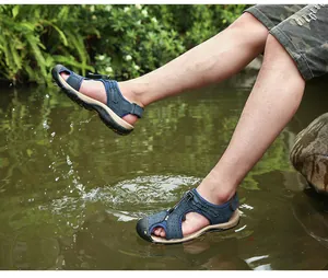 Nahaufnahme der atmungsaktiven, geschlossenen Herren-Sandalen beim Spritzen im Wasser.