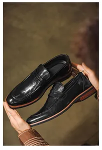 Detailed view of black leather penny loafers for men, English style slip-on shoes.