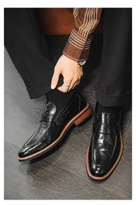 Detailed view of classic black leather penny loafers for men in a stylish business casual setting