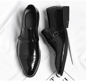 Close-up of black leather men's dress shoes with crocodile texture and buckle detail