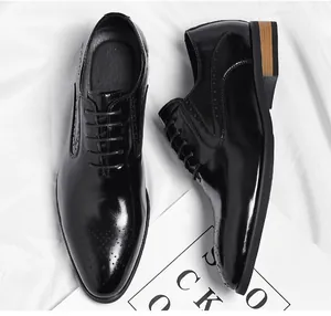 Detailed top view of black shiny Oxford leather shoes with brogue patterns