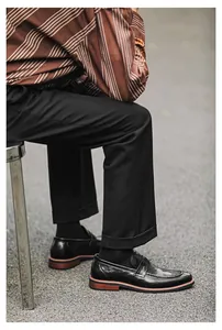 Men's British style black leather loafers in a casual outdoor lifestyle setting