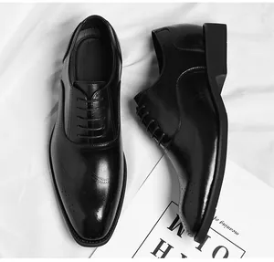Detailed top view of classic black leather men's dress shoes with brogue detailing