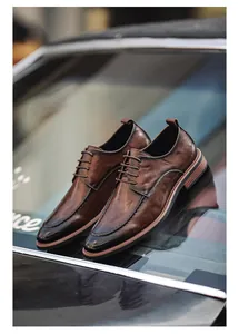 Detailed close-up of brown gradient men's business leather shoes on reflective surface