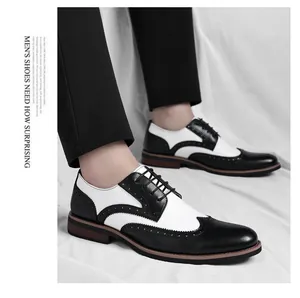 Detailweergave van de klassieke zwart-witte Brogue leren schoenen voor herenmode-kleding.