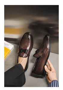 Close-up view of premium brown leather loafers with textured toe and elegant black buckle