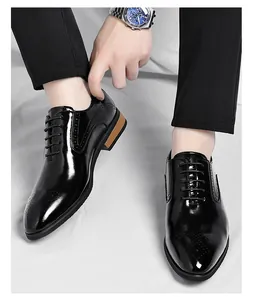 Close-up detail of shiny black men's British style formal oxford shoes with brogue engraving