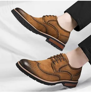 Detail of men's tan suede brogue shoes with classic wingtip decorative perforations.