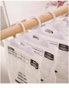 Detailed view of white hanging dehumidifier bags filled with moisture absorbing beads