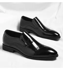 Detailed view of men's black shiny slip-on business dress shoes with elegant brogue design