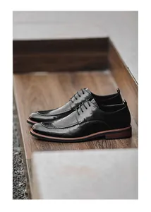 Close-up of black formal leather shoes for men on a wooden steps background