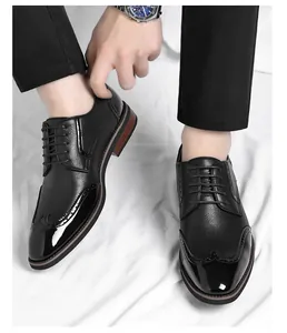 Close-up of black men's brogue wingtip dress shoes with patent leather details.