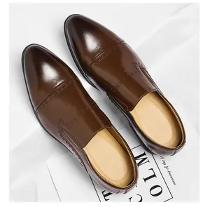 High-quality detail view of brown men's slip-on formal leather shoes with brogue punch patterns