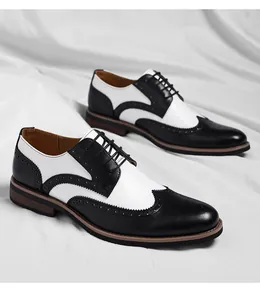Detailopname van zwart-witte brogue herenschoenen met klassiek wingtip patroon