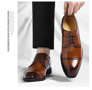 Detail van bruine leren zakelijke schoenen met elegant brogue-motief op de neus
