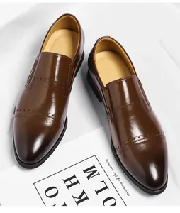Detailed view of brown men's formal dress shoes with brogue detailing on white background