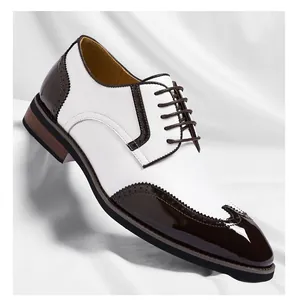 Close-up of men's two-tone white and brown leather brogue dress shoes with wingtip detail