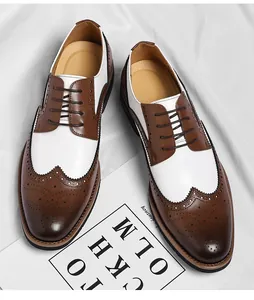 Detail van tweekleurige wit-bruine brogue lederen herenschoenen met gaatjespatroon
