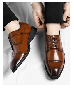 Detailopname van bruine leren herenschoenen met brogue-details en krokodillenprint.