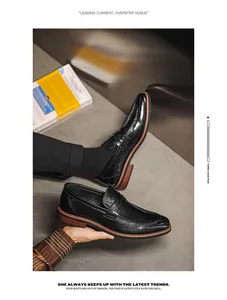 Close-up detail of black leather pointed-toe loafers in a modern industrial setting.