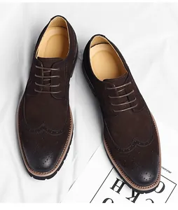 Close-up macro view of men's brown suede wingtip Oxford shoes with brogue detailing