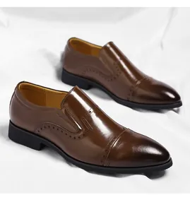 Men's brown pointed-toe formal leather loafers with brogue details on white fabric background