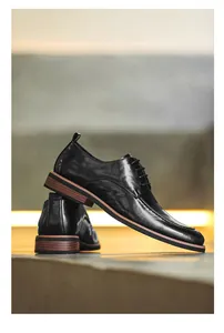 Detail view of polished black leather business dress shoes with wooden textured sole