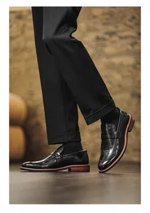 Detailed view of men's black leather penny loafers featuring stylish red sole accents