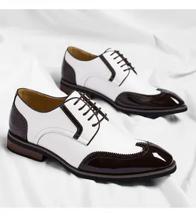 Close-up of men's white and brown wingtip Brogue dress shoes with decorative perforations.