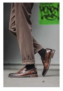 Close-up detail of men's brown leather loafers with vintage finish and slip-on design