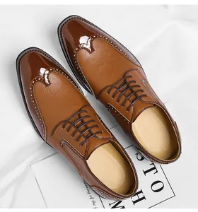 Close-up of tan men's brogue shoes with decorative perforation detail.